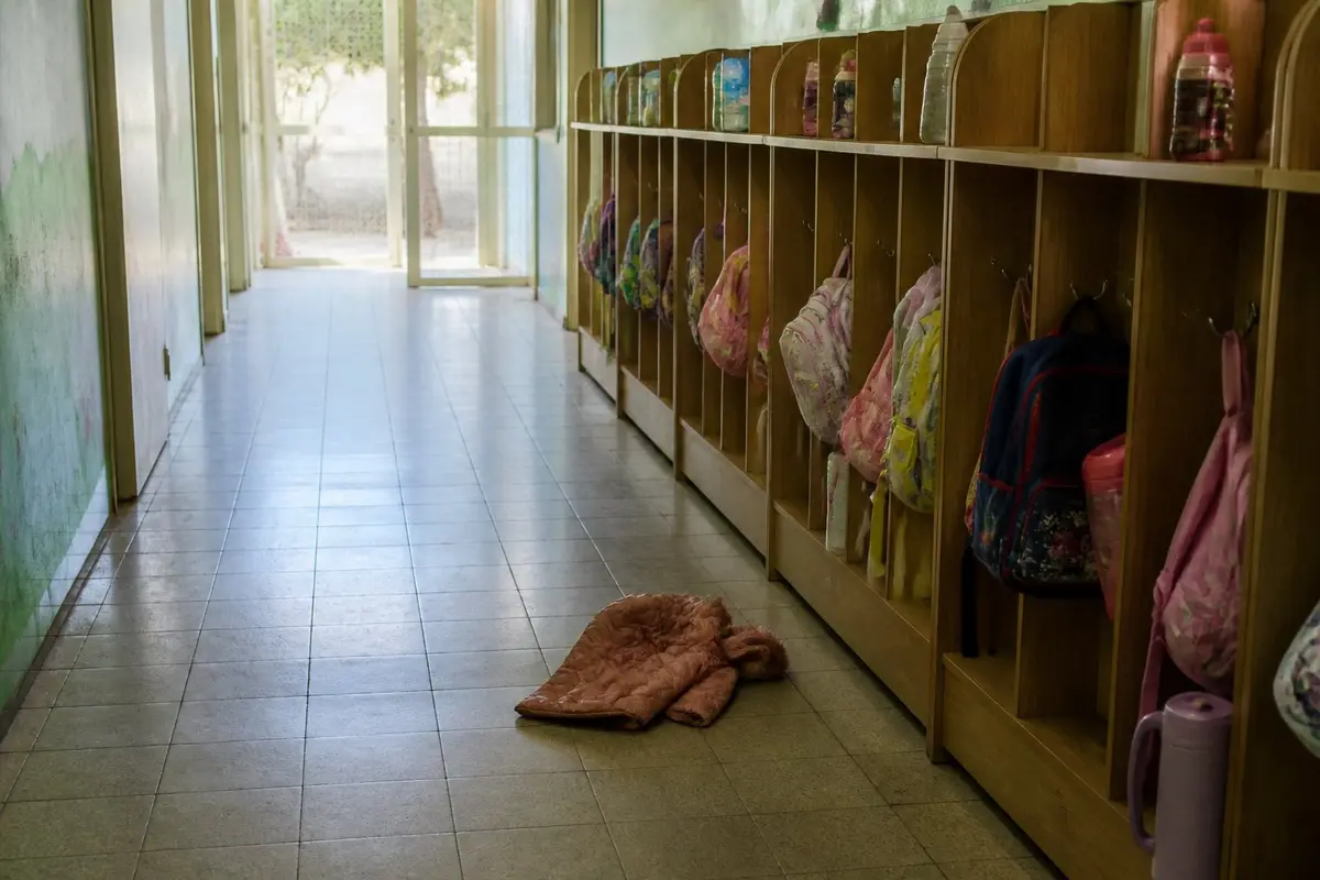 הרבה מכות בגן קורות במעברים: מהחצר פנימה, מהמשחק לארוחה, מהבוקר עם ההורים לגננת. מסדרון בגן ילדים בבוקר: שורת תאים נמוכים עם תיקים קטנים ובקבוקי מים, ומעיל קטן אחד שנפל על הרצפה